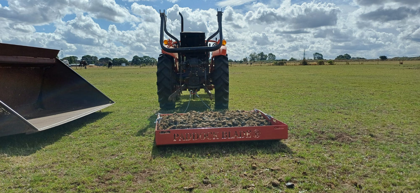 Signal red Paddock Blade horse paddock cleaner by Paddock Blade UK, showing the durable blade and handle in a paddock setting.