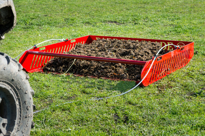 Red Paddock Blade horse paddock cleaner with sturdy handle, designed for efficient paddock maintenance by Paddock Blade UK.